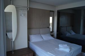a bedroom with two beds with white sheets and a mirror at Gio-Ma in Plakias