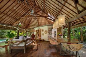 a kitchen and living room with a wooden ceiling at Villa Maia in Kerobokan