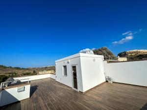 ein weißes Haus mit einem Dach mit blauem Himmel in der Unterkunft Dar Sara Gozo in Victoria