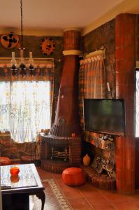 a living room with a fireplace and a tv at Villa Authentique avec Vue Panoramique à 3 km de Chefchaouen in Chefchaouene