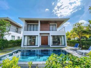 a house with a swimming pool in front of a house at Anise villas in Phu Quoc