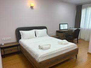 a bedroom with a bed with two towels on it at Hotel Four Season in Tbilisi City