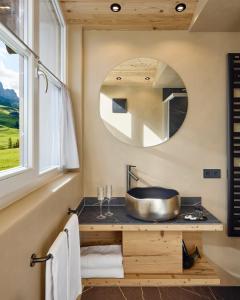 een badkamer met een wastafel en een spiegel bij Appartamenti Les Viles in La Villa