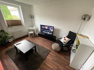Wohnung in Herne Zentral mit Küche, Netflix, Disney Plus, DAZN في هيرن: غرفة معيشة مع طاولة وتلفزيون