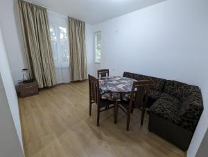 ein Wohnzimmer mit einem Tisch und einem Sofa in der Unterkunft Апартамент Габи in Karlowo