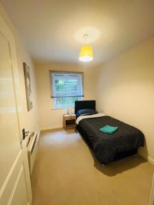 a bedroom with a black bed and a window at The rest point in Bletchley
