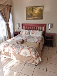 1 dormitorio con 1 cama, 2 mesitas de noche y 2 ventanas en 24 Topanga, en Uvongo Beach
