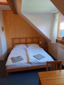 uma cama com duas almofadas num quarto em Apartmány Mladé Buky em Mladé Buky