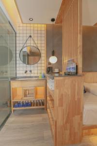 una cocina con fregadero y una cama en una habitación en Cozy Boutique Hotel, en Zhangjiajie