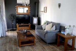 a living room with a couch and a tv at The Summer Haven in Polis Chrysochous