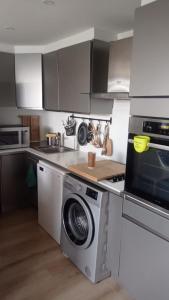 een keuken met een wasmachine en een magnetron bij Dîner vue mer avec l'Estérel in Les Adrets de l'Esterel