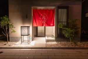 una bandera roja en el lateral de un edificio en Irodori Hotel AKANE en Fukuoka
