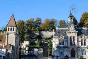 un vecchio edificio con una torre dell'orologio e una chiesa di Appart hypercentre Château-Thierry aux portes de Paris et de la Champagne a Château-Thierry Altre 11 foto