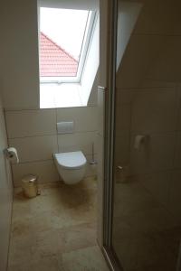 bagno con servizi igienici e finestra. di Ferienwohnung & Wellness a Bad Kissingen
