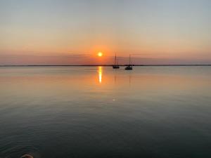 two boats on the water at sunset at zum Sanddorn in Saal +5 photos