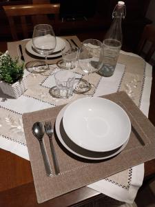 een tafel met een witte plaat, vork en mes bij Casa Cozy - Comodo Appartamento in Asti Centro in Asti