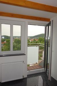 Zimmer mit 2 Fenstern und einem Balkon in der Unterkunft Ferienwohnung & Wellness in Bad Kissingen