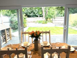 a dining room table with a vase of flowers on it at Number 8 in Midhurst