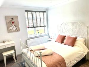 a bedroom with a white bed and a window at Number 8 in Midhurst