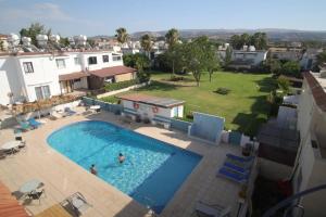 una vista aérea de una piscina con dos personas en ella en The Summer Haven en Polis Chrysochous
