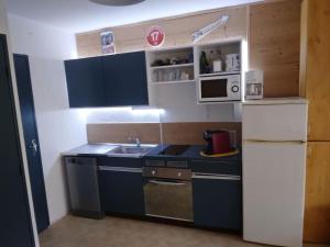 a small kitchen with a sink and a refrigerator at Studio tout confort in Lamoura