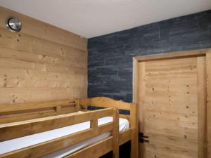 een slaapkamer met 2 stapelbedden en een houten deur bij Studio tout confort in Lamoura
