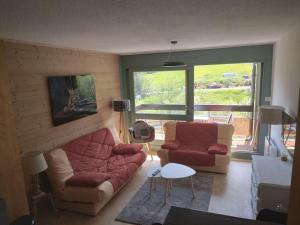 a living room with a couch and two chairs at Studio tout confort in Lamoura