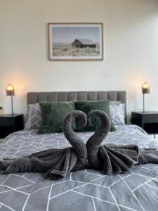two swans making a heart on a bed at Luxury Top Level 1 Bedroom Apartment with Stunning View in Adelaide CBD - 1 minute walk to Rundle mall - Free Wifi & Netflix in Adelaide