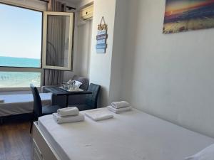 a room with a bed and a table and a window at Arteg Apartments - Full Sea View in Durrës