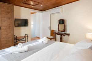 a bedroom with a large white bed with towels on it at Guest house (Gastouri) in Gastouri