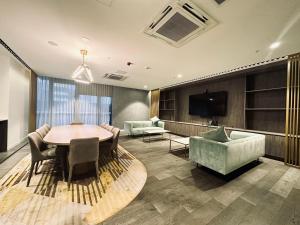 uma sala de estar com uma mesa e cadeiras e uma televisão em Luxury Top Level 1 Bedroom Apartment with Stunning View in Adelaide CBD - 1 minute walk to Rundle mall - Free Wifi & Netflix em Adelaide