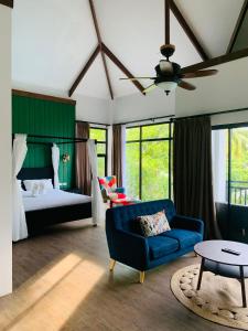 - une chambre avec un canapé bleu et un lit dans l'établissement Tana Mysterious garden, à Panglao