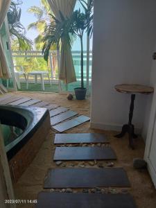 Departamento en playa caleta في أكابولكو: غرفة مع حوض استحمام وطاولة والنخيل
