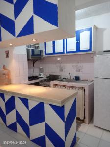 a kitchen with a blue and white checkered wall at Departamento en playa caleta in Acapulco