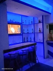 a bar with blue lights in a room at Departamento en playa caleta in Acapulco
