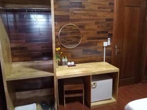 y baño con pared de madera y espejo. en Domnak Teuk Chhou, en Kampot