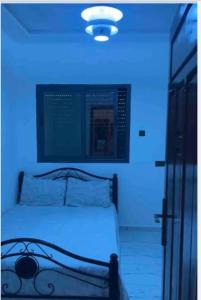 a bed in a room with a blue light at Imsouane in Imsouane