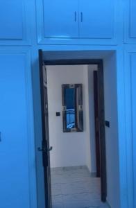 a hallway with a blue door and a mirror at Imsouane in Imsouane