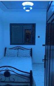 a bed with a blue light in a room at Imsouane in Imsouane
