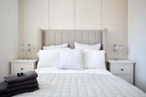 1 dormitorio con 1 cama blanca grande con almohadas blancas en Freshly Refurbished Open-plan Dining & Kitchen, en Norwich