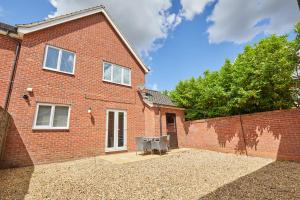 una casa de ladrillo con un banco delante de ella en Freshly Refurbished Open-plan Dining & Kitchen, en Norwich