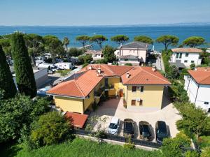 an aerial view of a yellow house with red roofs at Haus Romagnoli Residence in Lazise