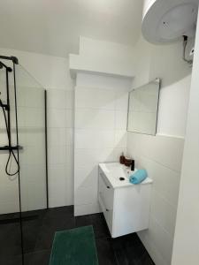 uma casa de banho branca com um lavatório e um espelho em GROSS - REAL ESTATE em Leoben