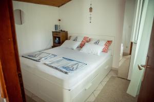 Un dormitorio con una cama blanca con almohadas rojas y blancas en Felix Apartment Biograd, en Biograd na Moru