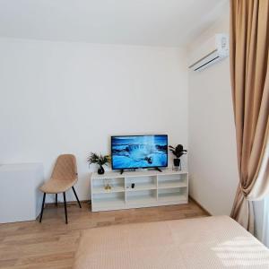 een woonkamer met een tv en een stoel bij Смарт квартира в ЖК Комфорт Таун in Kiev