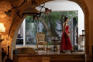 Le Foglie Di Acanto في لوتشرا: امرأة ترتدي ثوب احمر تمشي في الممر