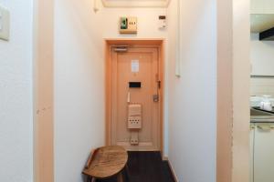 a small room with a door and a wooden stool at Grace Heiwajima in Tokyo