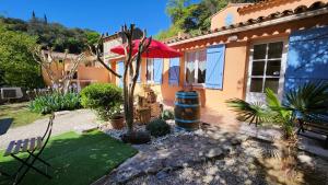 a house with a garden and a red umbrella at La cascade de Carcès in Carcès