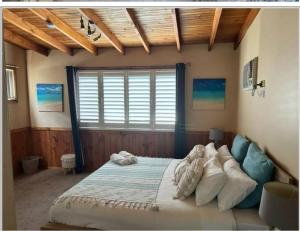 a bedroom with a bed and a large window at VIVID - House w heated pool, ev station, fireplace in Summerland Point