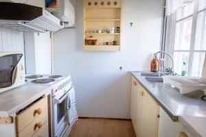 a kitchen with a stove top oven next to a sink at Trevligt fritidshus 20 km utanför Falun Dalarna in Falun